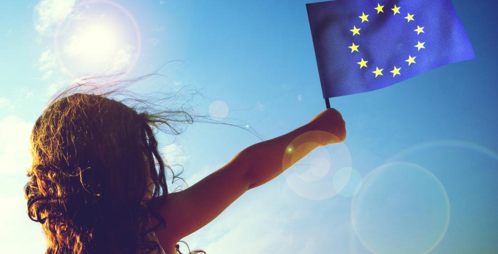 Liten jente vifter med et EU-flagg