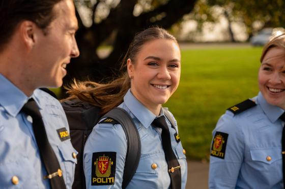 Tre politistudenter går ute med grønt gress i bakgrunnen