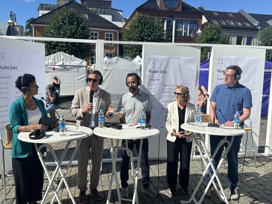 Ordstyrer og fire paneldeltakere p&aring; scenen ute p&aring; Arendal torv