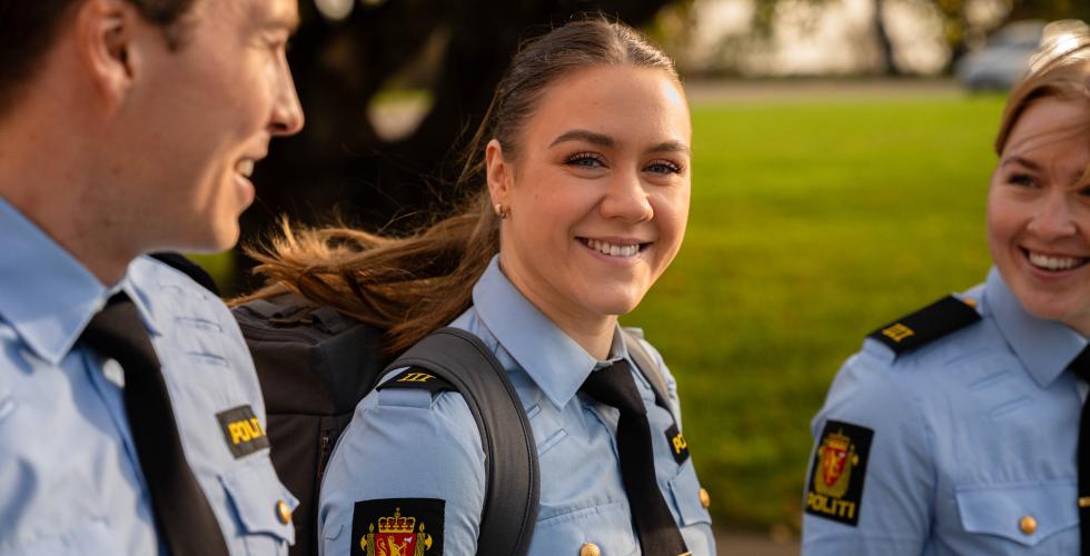 Tre politistudenter går ute med grønt gress i bakgrunnen