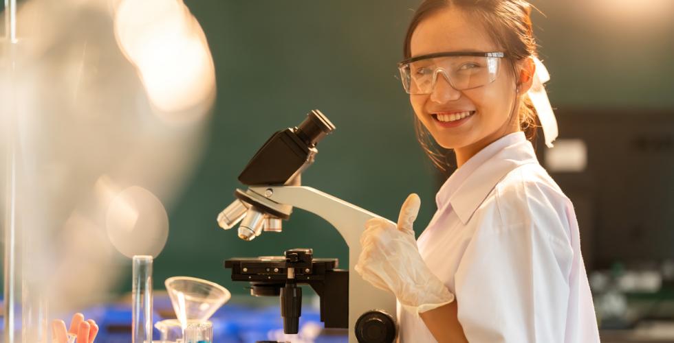 Bilde av en ung, kvinnelig kjemiker i en lab