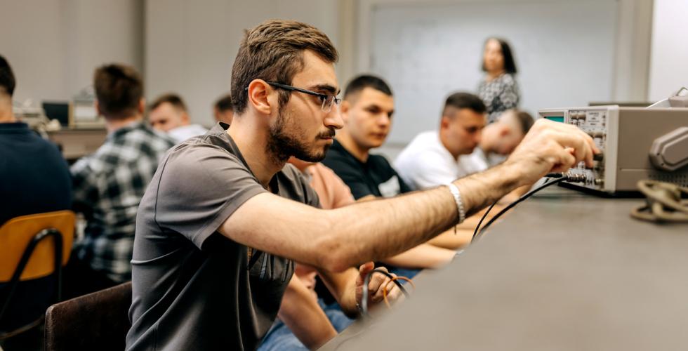 En gruppe mannlige ingeniørstudenter sitter og jobber i et klasserom