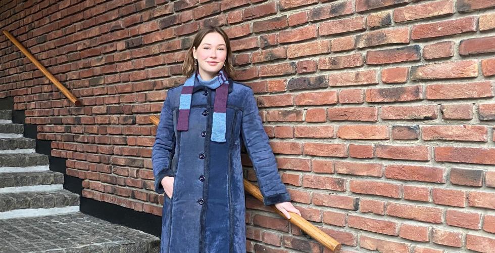 Stipendiat Thora Bjørke Sandberg i trappen utenfor Institutt for samfunnsforskning