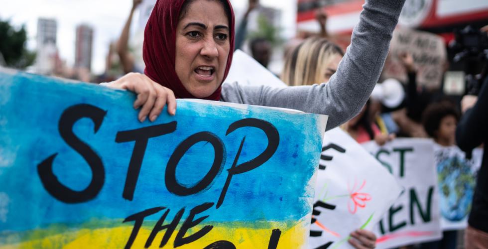 Kvinne demonstrerer med plakat "Stop the war" i Ukraina