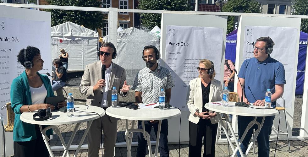 Ordstyrer og fire paneldeltakere p&aring; scenen ute p&aring; Arendal torv